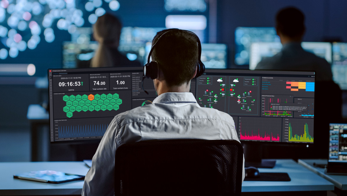 Profesional monitoreando sistemas en múltiples pantallas